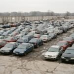 Pátio de apreensão do Detran com fileiras de carros usados